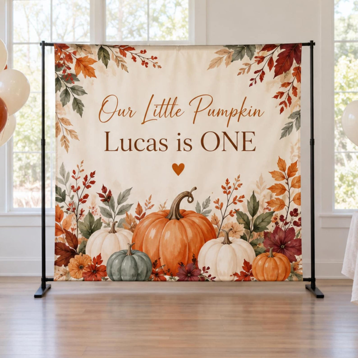 Our Little Pumpkin first birthday backdrop with orange, cream and green pumpkins and autumn leaves.