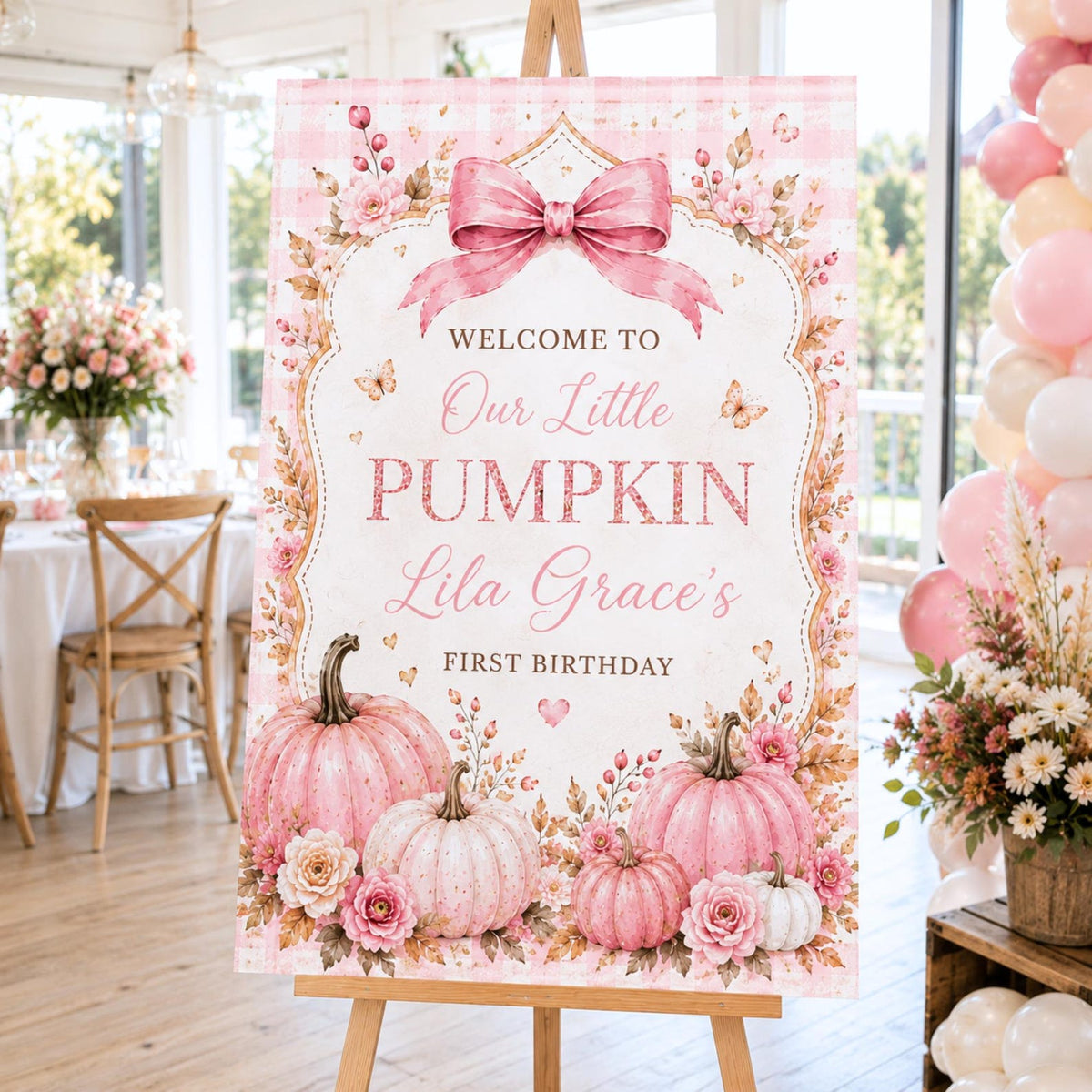 Pink Our Little Pumpkin first birthday welcome sign with a large bow, roses and personalized name.
