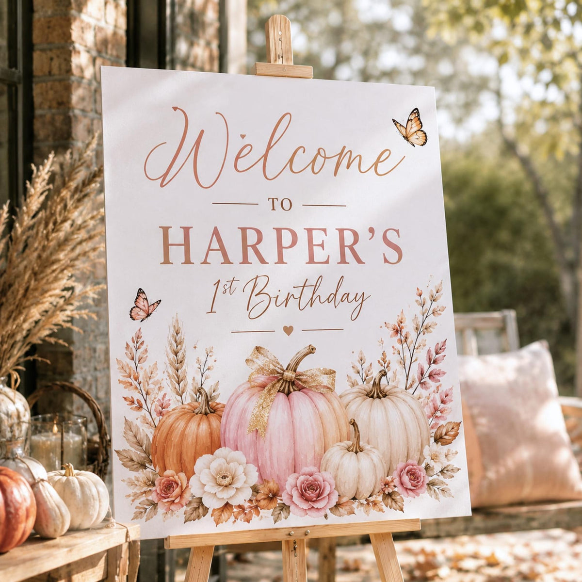 First birthday welcome sign with blush and cream pumpkins, flowers and butterflies.