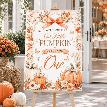 Our Little Pumpkin Is Turning One welcome sign with orange bow, pumpkins and flowers.