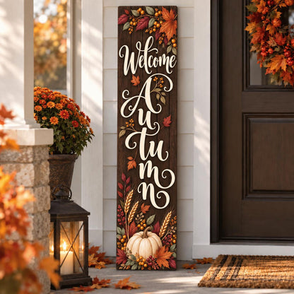 Welcome Autumn porch sign with a dark wood-look print, colorful leaves, wheat and a white pumpkin.